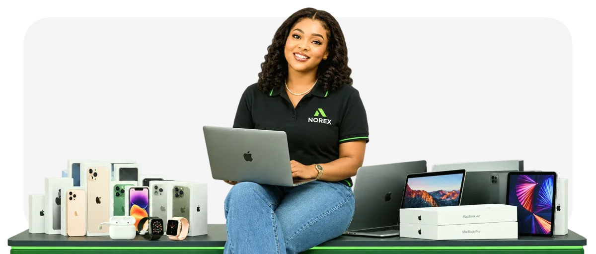 A Norex agent with a laptop, sitting beside rows of boxed phones, watches and laptops